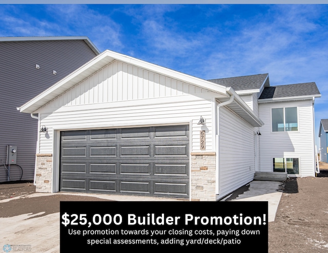 6729 67th Ave S, Horace, ND 58047 - view of home's exterior with stone siding, a garage, and driveway