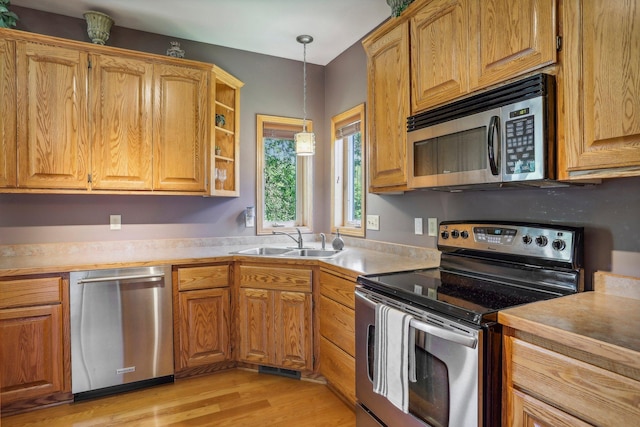 6875 148th Ln NW, Ramsey, MN 55303 - kitchen with appliances with stainless steel finishes, a sink, hanging light fixtures, light wood-type flooring, and light countertops