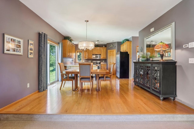6875 148th Ln NW, Ramsey, MN 55303 - dining room with a chandelier, light wood-style flooring, and baseboards
