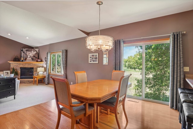 6875 148th Ln NW, Ramsey, MN 55303 - dining space with a chandelier, light wood-style flooring, healthy amount of natural light, a stone fireplace, and vaulted ceiling