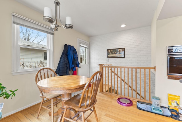 dining room with baseboards, recessed lighting, wood finished floors, and a chandelier
