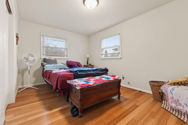 bedroom with light wood-style floors, crown molding, and multiple windows