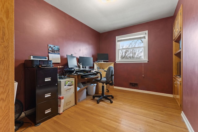 home office featuring visible vents, light wood-type flooring, and baseboards