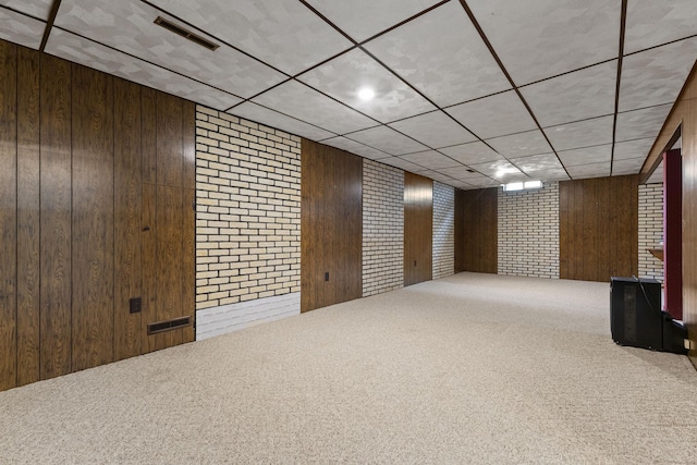 finished below grade area featuring visible vents, wood walls, and carpet floors