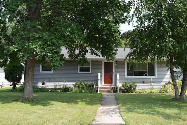 view of front facade with a front lawn and roof with shingles