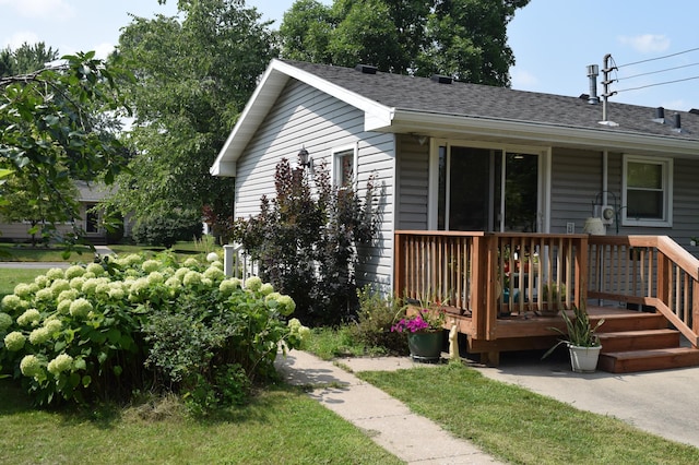 view of property exterior with a deck and a shingled roof