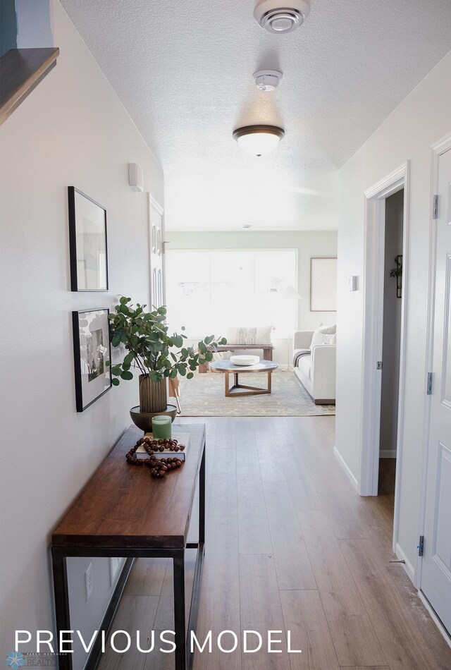6745 Meadow View Dr S, Fargo, ND 58104 - corridor with a textured ceiling and wood finished floors