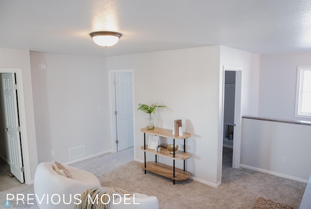 living area featuring visible vents, baseboards, and carpet floors