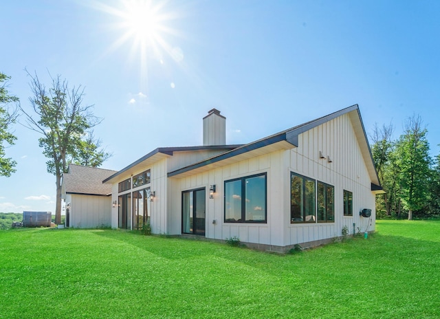 38525 Northstar Dr, Cushing, MN 56443 - back of house with board and batten siding, a chimney, and a yard