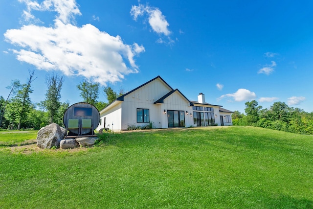 38525 Northstar Dr, Cushing, MN 56443 - back of property featuring board and batten siding, a chimney, and a yard
