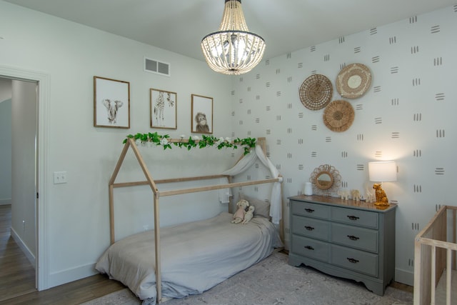 38525 Northstar Dr, Cushing, MN 56443 - bedroom featuring visible vents, wood finished floors, an inviting chandelier, wallpapered walls, and baseboards