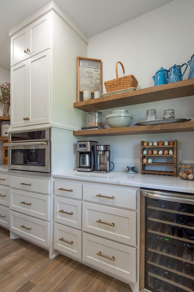 38525 Northstar Dr, Cushing, MN 56443 - bar featuring stainless steel oven, light wood-type flooring, and beverage cooler