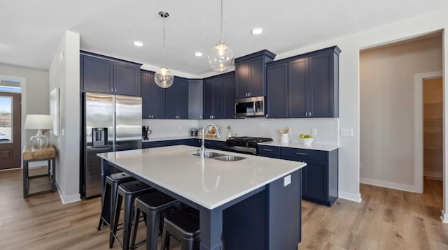 kitchen with a sink, baseboards, a breakfast bar area, and stainless steel appliances