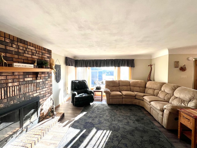 living room featuring dark wood-style floors and a brick fireplace