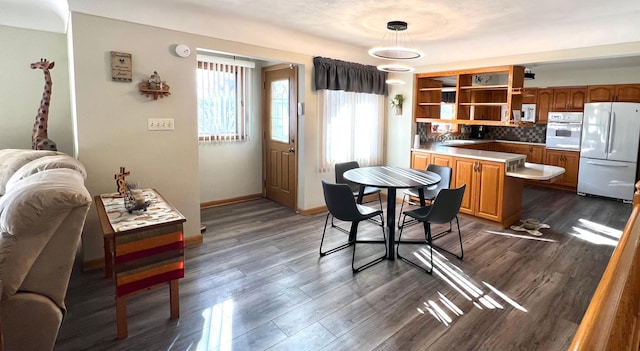 kitchen with white appliances, light countertops, dark wood-type flooring, and tasteful backsplash