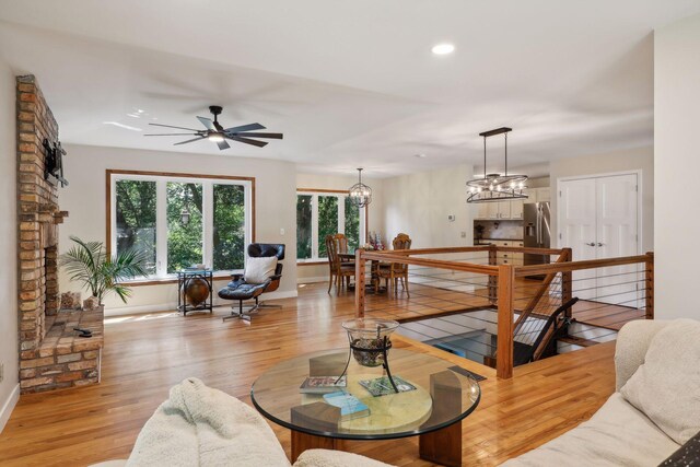 17180 Jordan Ct, Lakeville, MN 55044 - living area featuring baseboards, light wood-style flooring, recessed lighting, a ceiling fan, and a chandelier