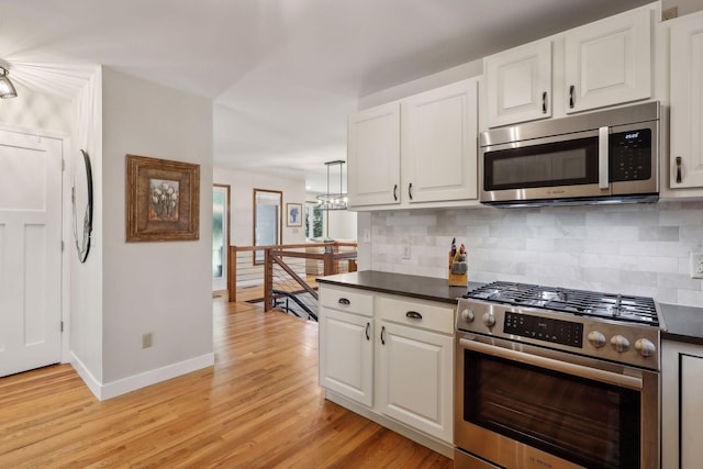 17180 Jordan Ct, Lakeville, MN 55044 - kitchen featuring stainless steel appliances, decorative backsplash, light wood-style flooring, baseboards, and dark countertops