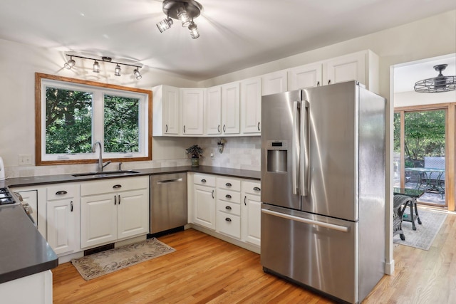 17180 Jordan Ct, Lakeville, MN 55044 - kitchen featuring appliances with stainless steel finishes, a sink, dark countertops, and white cabinetry