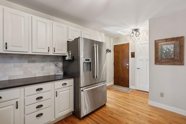 17180 Jordan Ct, Lakeville, MN 55044 - kitchen with stainless steel fridge, backsplash, dark countertops, light wood-style flooring, and white cabinets