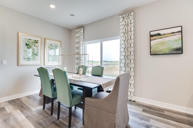 dining area featuring wood finished floors, baseboards, and recessed lighting