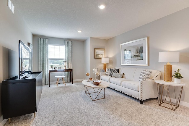 carpeted living area with baseboards, recessed lighting, and a textured ceiling