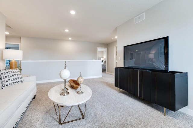living room featuring recessed lighting, visible vents, baseboards, and light carpet