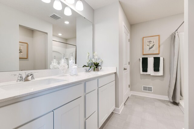 full bath with baseboards, visible vents, a sink, and a shower with shower curtain