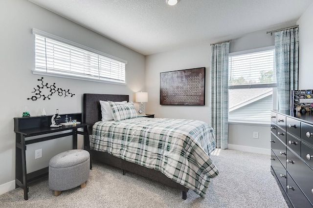 carpeted bedroom featuring multiple windows, a textured ceiling, and baseboards
