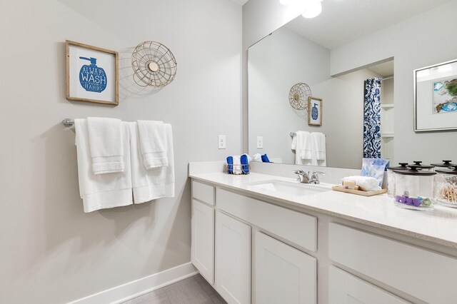 bathroom featuring vanity, baseboards, and a shower with curtain