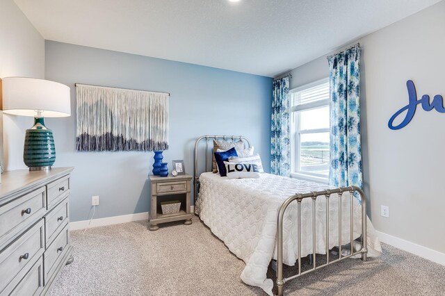 bedroom with light colored carpet and baseboards