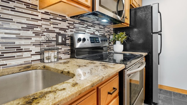 1800 Lasalle Ave Unit 106, Minneapolis, MN 55403 - kitchen featuring appliances with stainless steel finishes, tasteful backsplash, light stone countertops, brown cabinets, and a sink