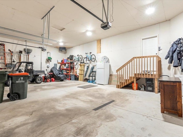 garage featuring freestanding refrigerator and a garage door opener