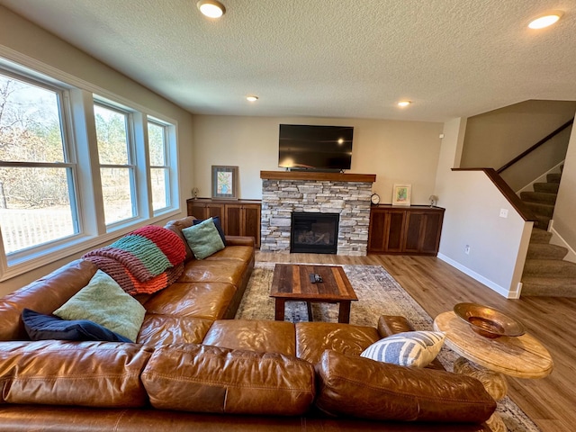 living room featuring a textured ceiling, wood finished floors, stairway, recessed lighting, and baseboards