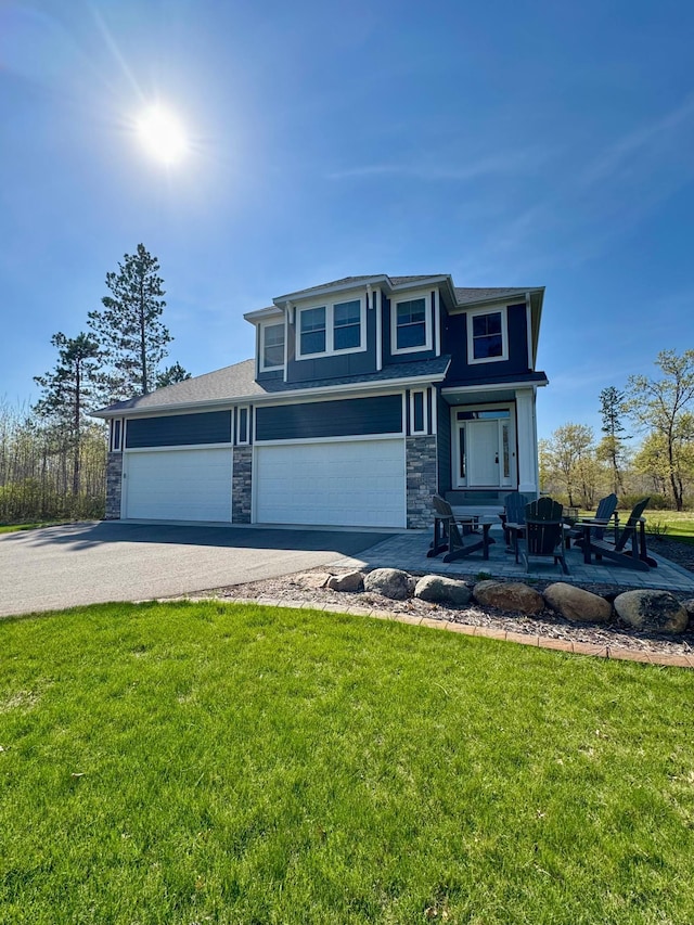 view of front of property featuring stone siding, a front lawn, and driveway