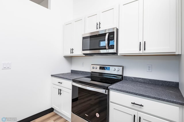 6741 67th Ave S, Horace, ND 58047 - kitchen featuring appliances with stainless steel finishes, white cabinetry, and light wood-style flooring