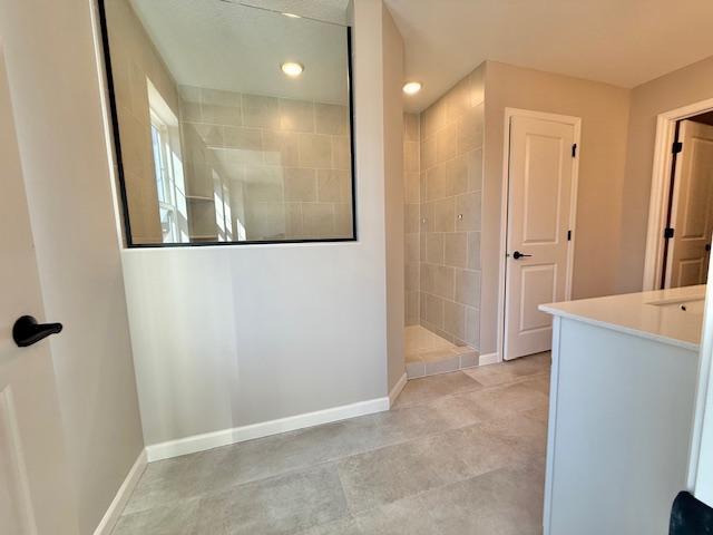 full bath featuring recessed lighting, baseboards, and walk in shower