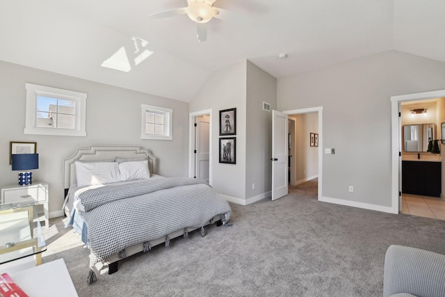 carpeted bedroom featuring baseboards, visible vents, ensuite bathroom, and lofted ceiling