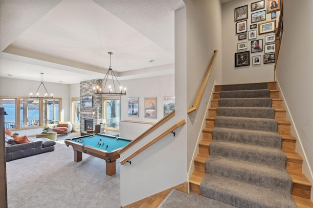 rec room featuring pool table, wood finished floors, baseboards, a notable chandelier, and a tray ceiling