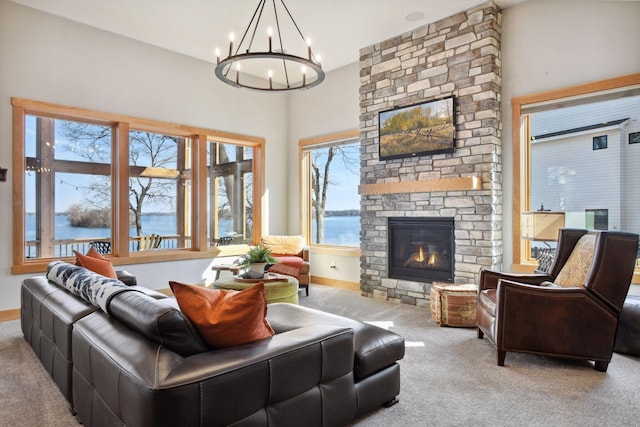 living room with baseboards, an inviting chandelier, a stone fireplace, and carpet