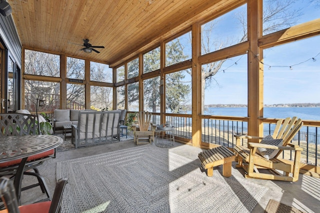 sunroom / solarium featuring a healthy amount of sunlight, a water view, ceiling fan, and an outdoor hangout area