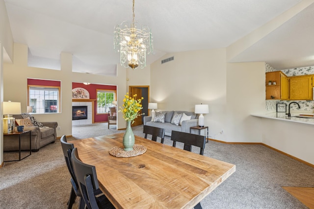 14 3rd St NW, Saint Michael, MN 55376 - dining area featuring carpet floors, a chandelier, a fireplace, lofted ceiling, and baseboards