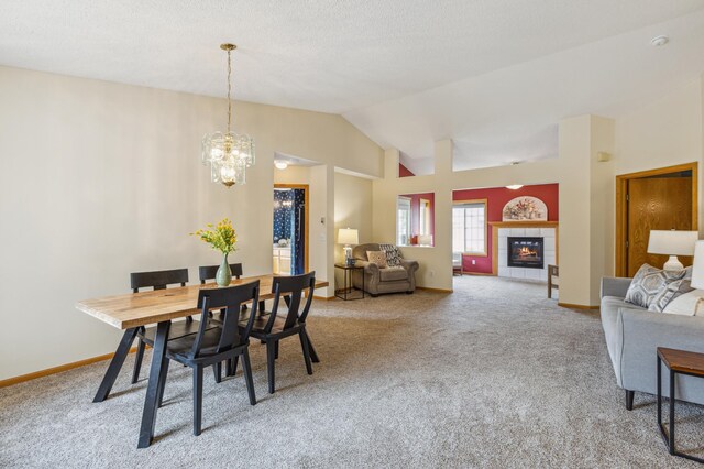 14 3rd St NW, Saint Michael, MN 55376 - dining space with carpet flooring, lofted ceiling, a chandelier, a tiled fireplace, and baseboards
