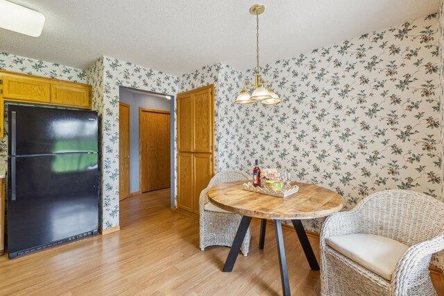 14 3rd St NW, Saint Michael, MN 55376 - dining area featuring wallpapered walls, light wood-style flooring, a textured ceiling, and baseboards