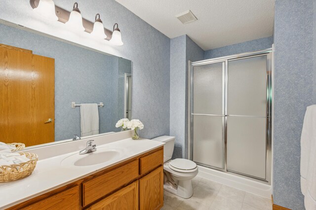 14 3rd St NW, Saint Michael, MN 55376 - bathroom featuring vanity, a shower stall, toilet, tile patterned floors, and a textured ceiling