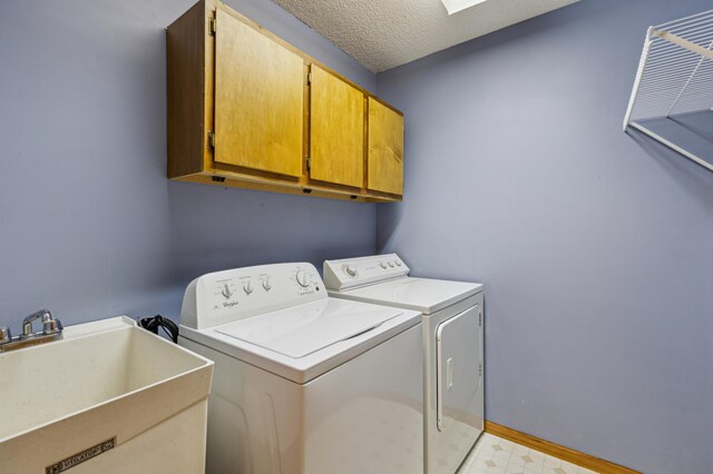 14 3rd St NW, Saint Michael, MN 55376 - washroom featuring cabinet space, independent washer and dryer, baseboards, and a textured ceiling