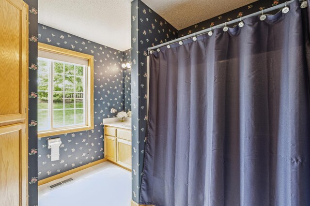 14 3rd St NW, Saint Michael, MN 55376 - bathroom with wallpapered walls, a textured ceiling, a shower with curtain, and vanity