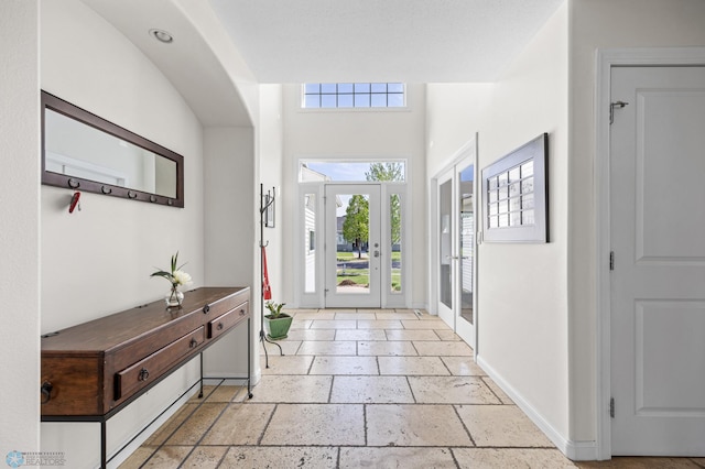 foyer entrance featuring stone tile floors and baseboards