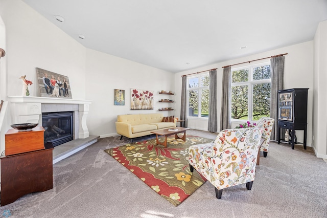 carpeted living area featuring a tiled fireplace, baseboards, and lofted ceiling