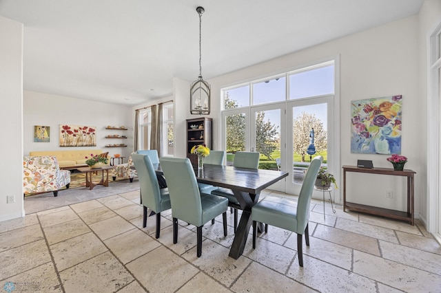 dining space with stone tile floors and baseboards