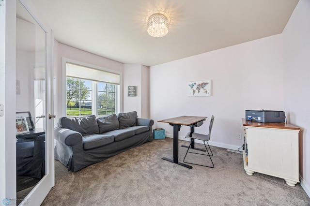 carpeted living room with a chandelier and baseboards
